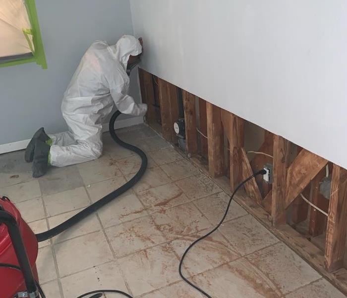 A person repairing drywall